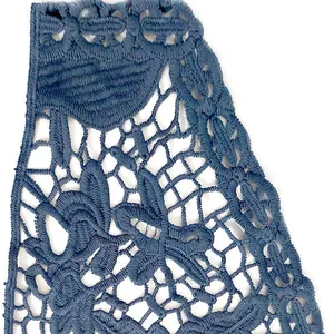 Vue macro du détail de la dentelle brodée en soie de lait bleue au design évidé floral