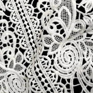 Close-up of white milk silk embroidery lace with intricate hollow floral pattern