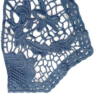 Gros plan détaillé de dentelle en soie de lait bleue avec motifs floraux ajourés brodés