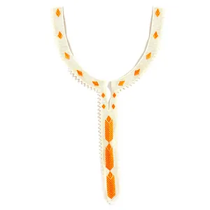 Détail d'une applique de col en dentelle brodée ethnique avec motifs géométriques orange.
