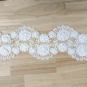 Detail view of white 3D floral lace embroidery trim with intricate hollowed patterns