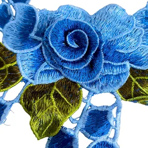 Vista macro di pizzo ricamato con rosa blu e foglie verdi per accessori di abbigliamento