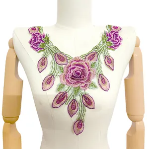 Detailansicht einer farbenfrohen Blumenstickerei-Spitzenapplikation auf einer Puppe.