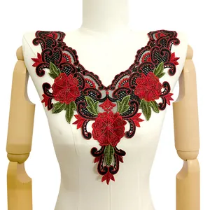 Detailed view of red and black floral lace embroidery collar on a white dress form