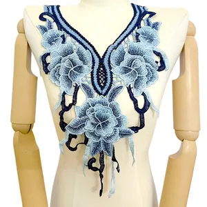 Gros plan détaillé d'un col en dentelle brodé de fleurs bleues sur un mannequin de couture