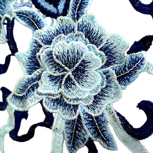 Vue rapprochée d'un patch en dentelle brodé floral bleu aux finitions détaillées.