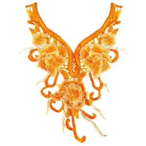 Gros plan sur une applique de col en dentelle brodée de fleurs orange vif ethnique.