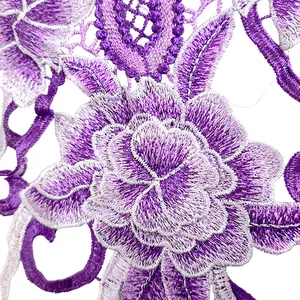 Gros plan sur un écusson en dentelle brodée de fleurs violettes détaillées