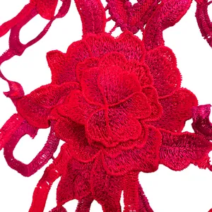 Vue macro montrant la texture complexe d'une applique de dentelle brodée rouge vif.