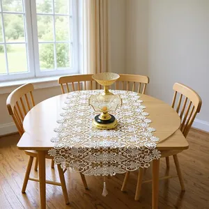 Detailed view of elegant white lace table runner with intricate 3D floral embroidery and tassel.