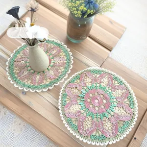 Detailed view of two colorful circular embroidered placemats with butterfly lace patterns.