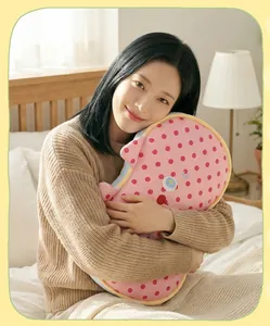 Asian woman hugging a pink polka dot cat-shaped memory foam nap pillow on a bed