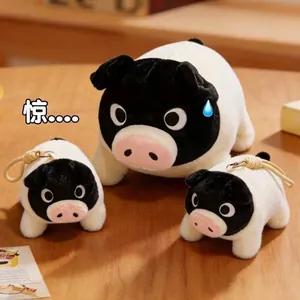 Soft black-faced pig plush toy set with keychain pendants on a light wood table background