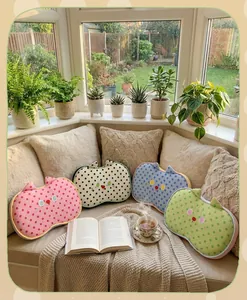 Cozy lifestyle setting featuring colorful polka dot cat-shaped memory foam nap pillows on a sofa