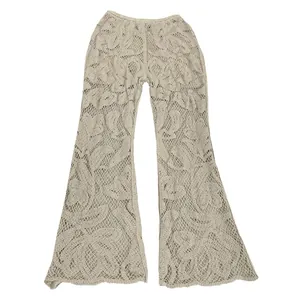 Detailed view of cream crochet lace flared trousers with intricate floral embroidery