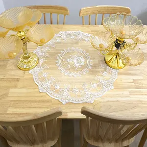 Detailed macro shot of vintage white embroidered floral lace doily on a wooden table