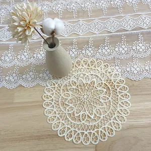 Detalle de posavasos redondo de encaje beige con bordado calado vintage