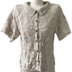 Detail of beige crochet lace cardigan top featuring intricate flower embroidery and lapel.