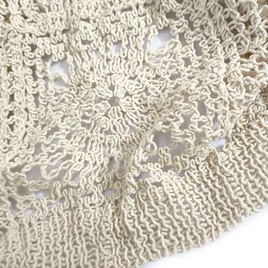 Close-up detail of cream hollow-out crochet knit pattern for women's cover-up