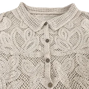 Macro view of beige crochet lace top showing intricate heart patterns and collar.