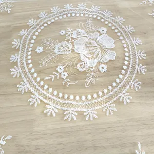 Detailed view of white floral embroidery on transparent mesh vintage lace placemat