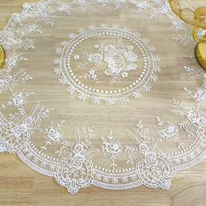Close-up detail of a vintage white lace placemat with intricate floral embroidery