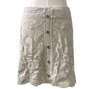 Close-up of beige crochet lace A-line skirt with decorative floral patterns and buttons