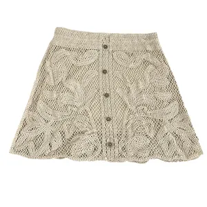 Detailed view of a beige crochet A-line mini skirt with floral embroidery and buttons.