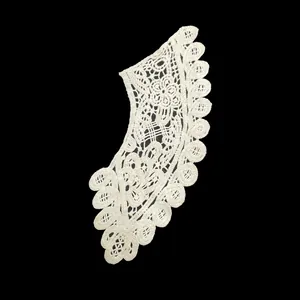 Detailed view of white cotton lace doll collar with intricate floral embroidery.