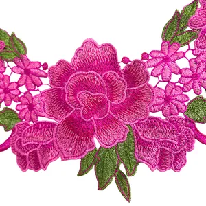 Detailopname van zware geborduurde kanten kraag met roze bloemen en groene bladeren