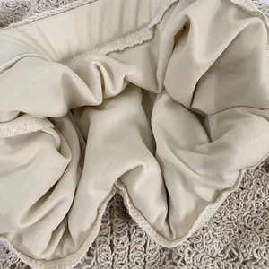 Close-up detail of soft cream lining and intricate crochet lace edge of a garment
