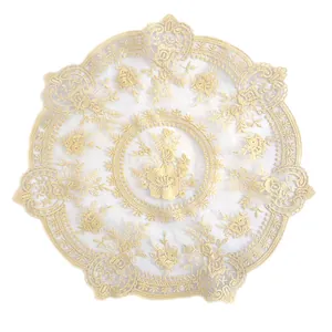 Macro view of intricate gold floral embroidery on transparent vintage lace mesh