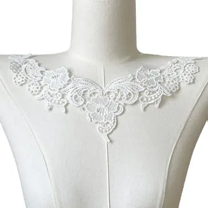 Detailed macro view of white milk silk embroidered lace collar applique on a mannequin