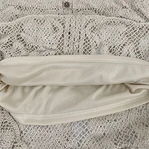 Close-up view of crochet lace cardigan showing soft inner lining and stitching detail