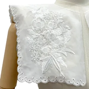 Detailed macro view of white floral embroidered detachable collar with scalloped lace edges