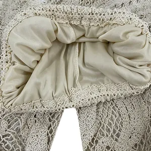 Close-up of beige crochet lace waistband with smooth inner lining and lace trim