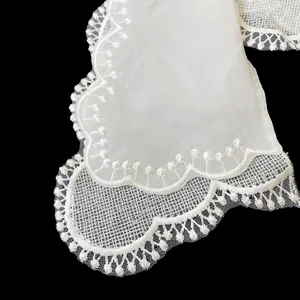 Close-up of white double-layered lace collar with intricate floral embroidery details.