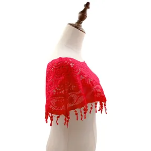 Vista detallada de un chal de encaje rojo con bordado calado y borlas decorativas