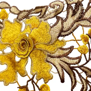 Detailed close-up view of vibrant yellow floral embroidery on delicate white lace fabric