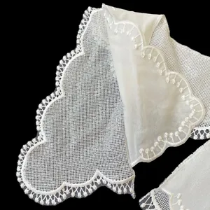 Exquisite detail view of white double-layered lace doll collar with embroidered edges