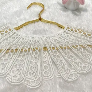 Detailed view of elegant white rope embroidered lace detachable collar on gold hanger