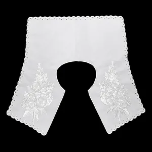 Close-up of white embroidered lace Peter Pan collar with floral hollow-out pattern