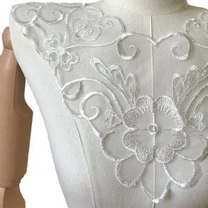 Detaillierter weißer Spitzenkragen mit Stickerei und elegantem Blumenmuster auf Schneiderpuppe