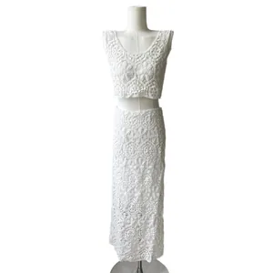Detailed macro shot of white cotton crochet two-piece set featuring hollow-out lace embroidery