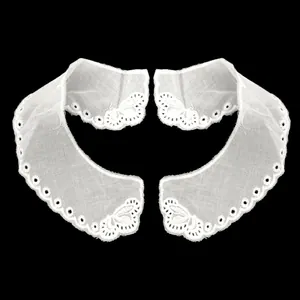 Dettaglio di un colletto in pizzo di cotone bianco ricamato con motivo floreale