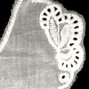Primo piano dell'intricato ricamo in cotone bianco e pizzo sul colletto staccabile