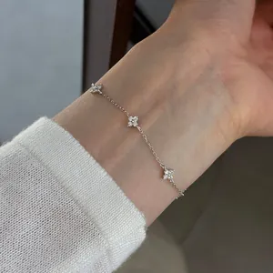 Close-up of a s925 silver four-leaf clover bracelet with sparkling cubic zirconia