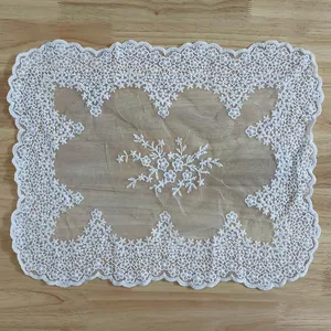 Detailed texture of rectangular white cotton lace tablecloth with floral embroidery