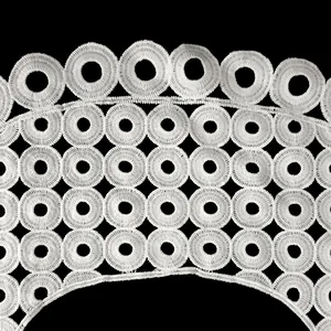 Détail de col en dentelle brodée blanche avec motifs circulaires ajourés