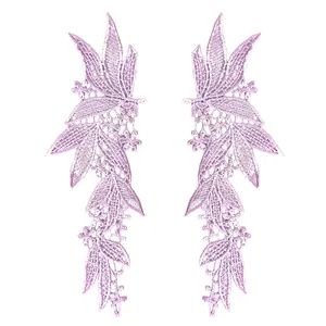 Detailed view of symmetrical purple floral lace embroidery patches for DIY clothing.
